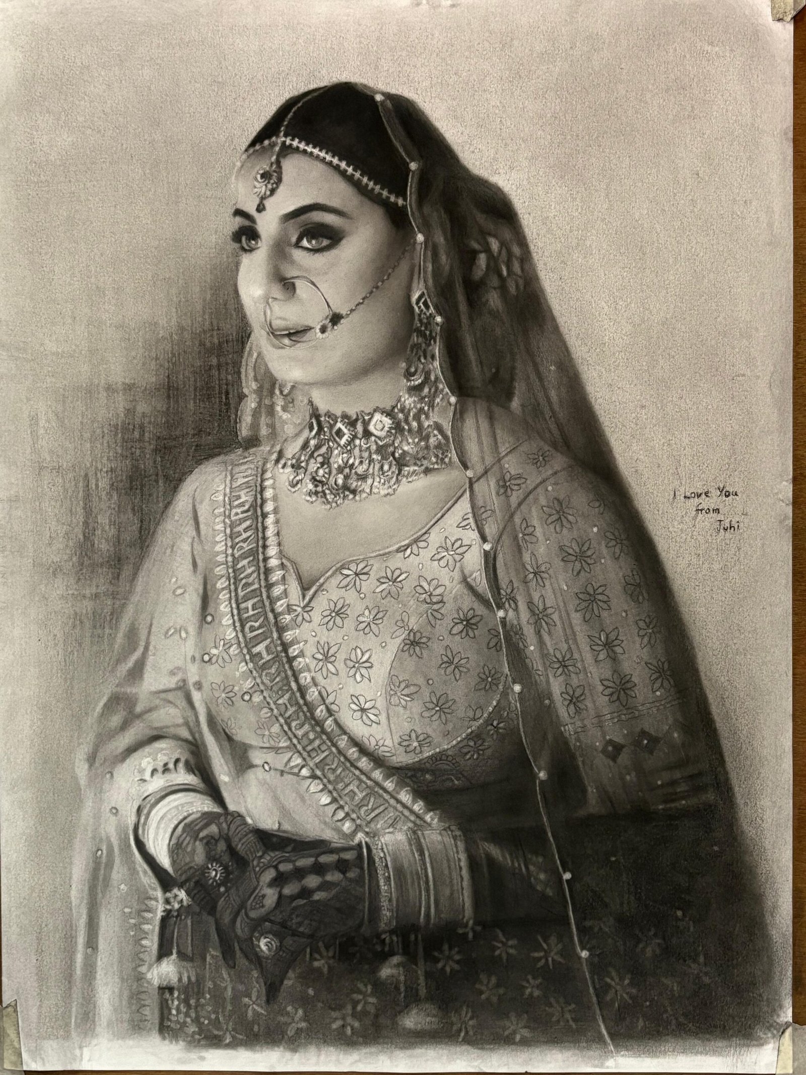 Durgesh standing between two large charcoal turban portraits at an exhibition