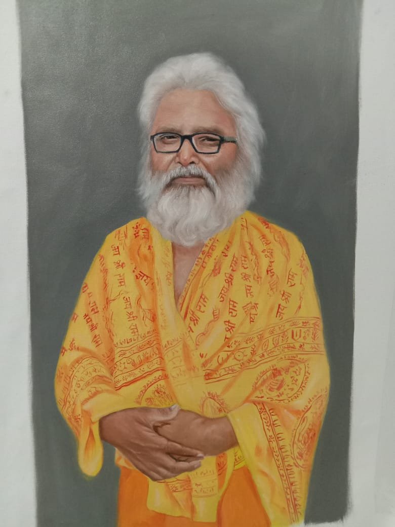 Durgesh standing between two large charcoal turban portraits at an exhibition