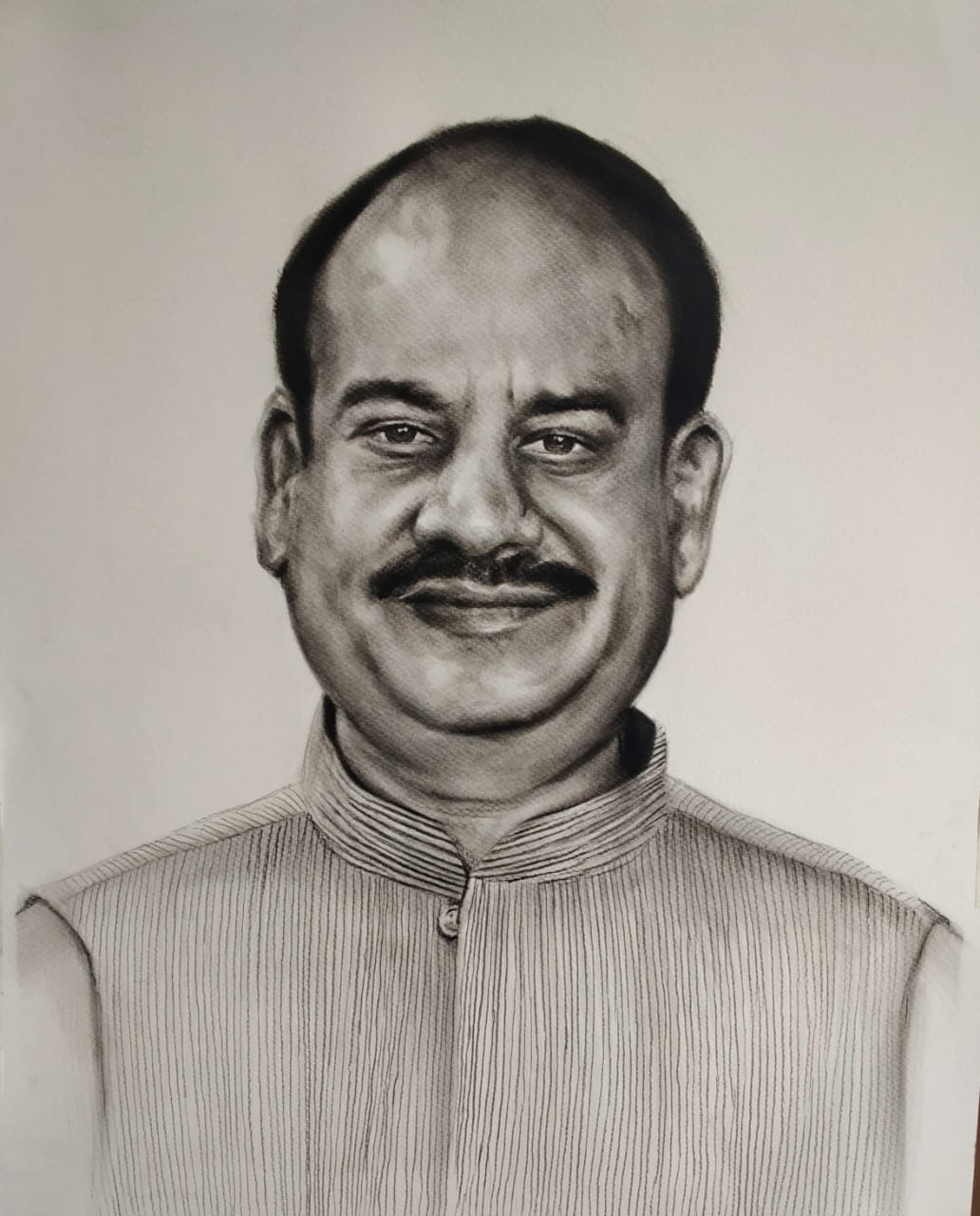 Durgesh standing between two large charcoal turban portraits at an exhibition